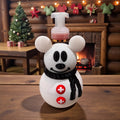 Snowman soap bottle holder with mouse ears and a chef's hat, standing in front of a decorated Christmas tree