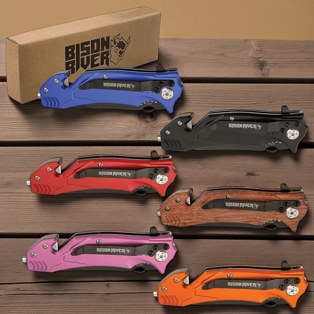Six Bison River rescue knives fanned out on a wooden surface in blue, red, pink, black, wood and orange, each in front of its kraft gift box