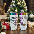 Two white Prism tumblers engraved Mindful, Demure, Bougie in rainbow lettering by a Christmas tree