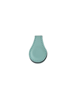Turquoise leatherette magnetic bookmark with a stitched edge, shown folded over a page