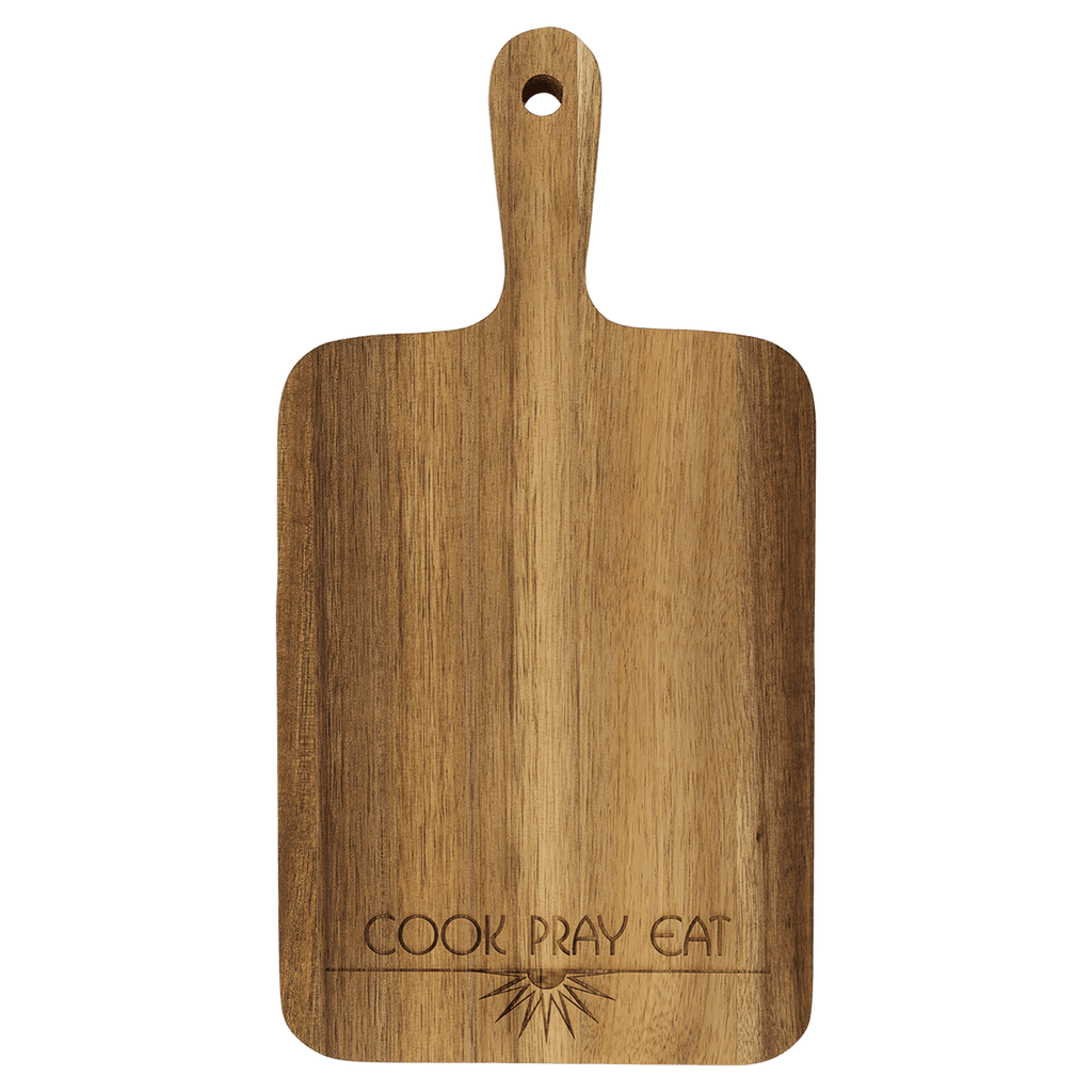 Acacia paddle cutting board engraved with 'Cook Pray Eat'