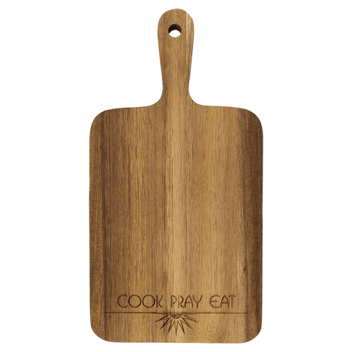 Acacia paddle cutting board engraved with 'Cook Pray Eat'