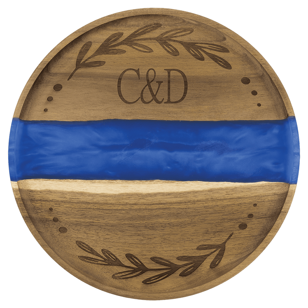 Round acacia serving tray with a blue pearl resin river and engraved monogram and wreath