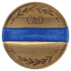 Round acacia serving tray with a blue pearl resin river and engraved monogram and wreath