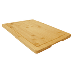 Angled view of a bamboo cutting board showing the depth of the juice groove