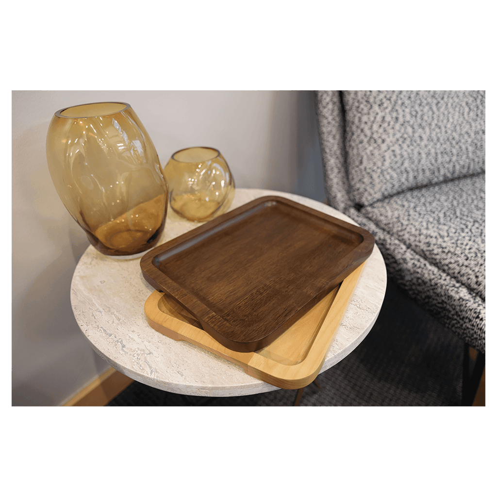 Alder and walnut trays stacked on a side table beside glass vases