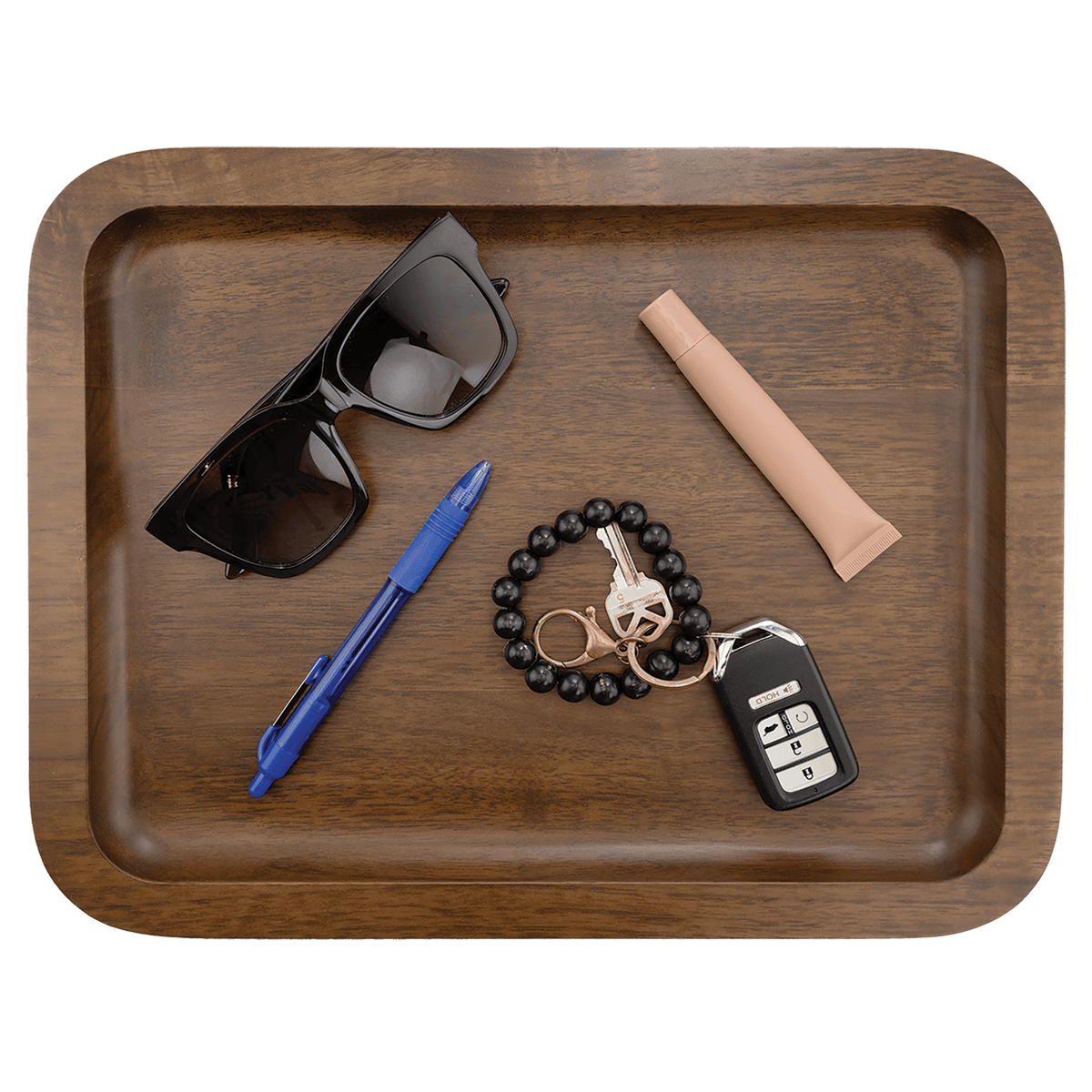 Walnut tray holding sunglasses, a pen, keys and a bracelet