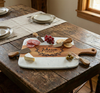 Marble and acacia serving board on a kitchen island, styled with cheese, crackers and fruit