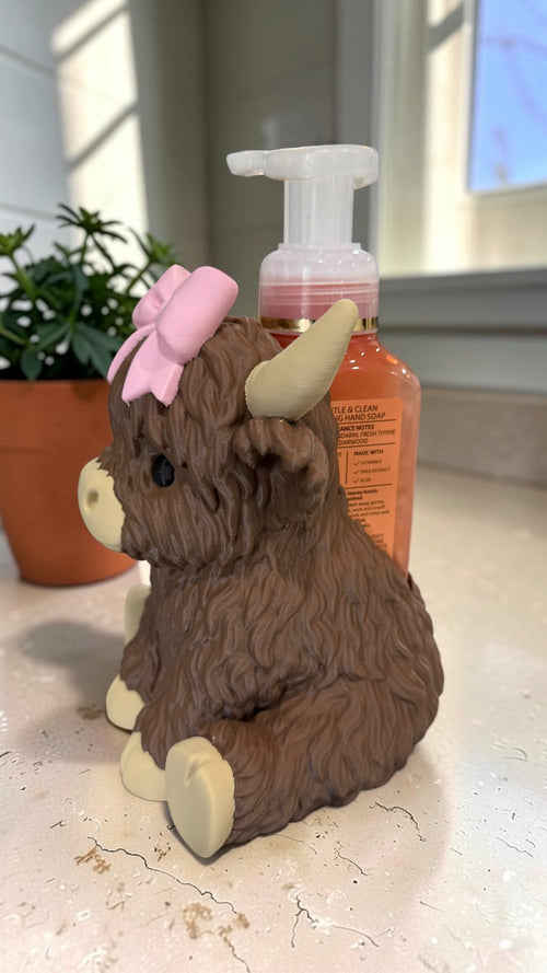 Side view of the Highland cow soap holder with a Bath & Body Works foaming soap bottle tucked in behind it