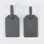 Gray leatherette luggage tag, front and back, with buckle strap