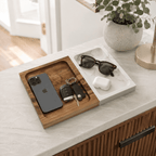 Marble and wood valet tray on a kitchen counter holding a phone, car keys, sunglasses and earbuds