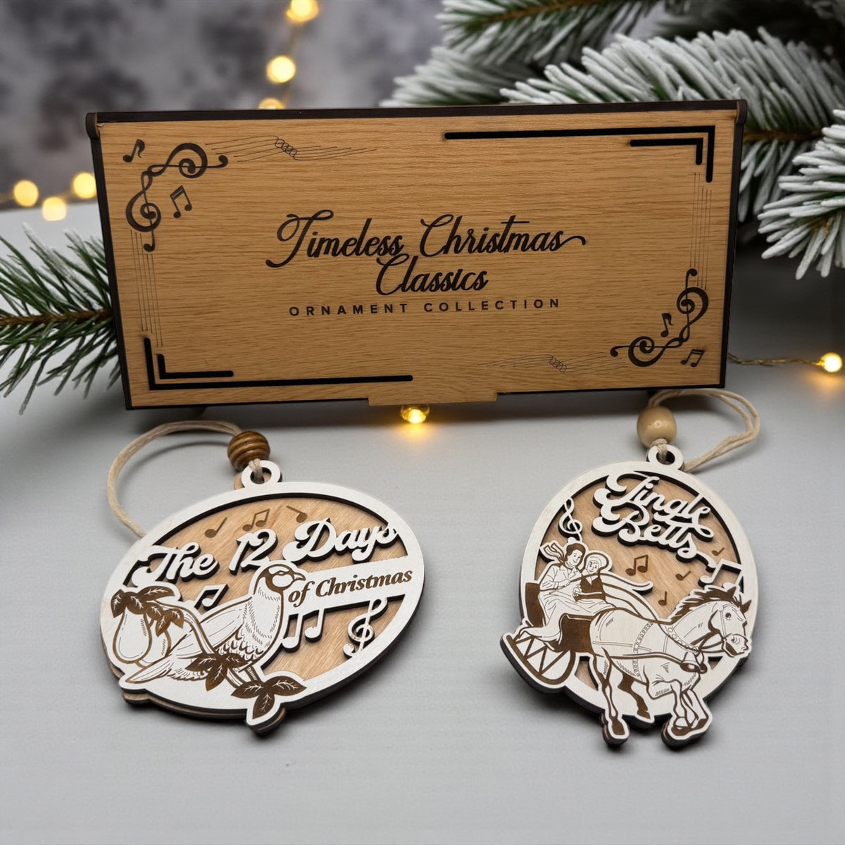 The ornament collection's engraved wooden gift box shown closed, with two of the carol ornaments beside it