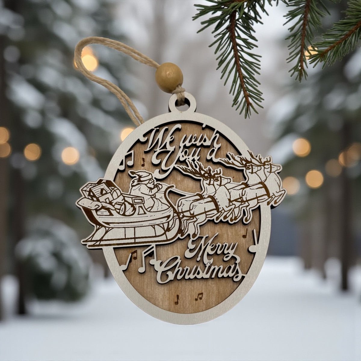 Wooden oval ornament engraved with a We Wish You a Merry Christmas scene, hanging in falling snow