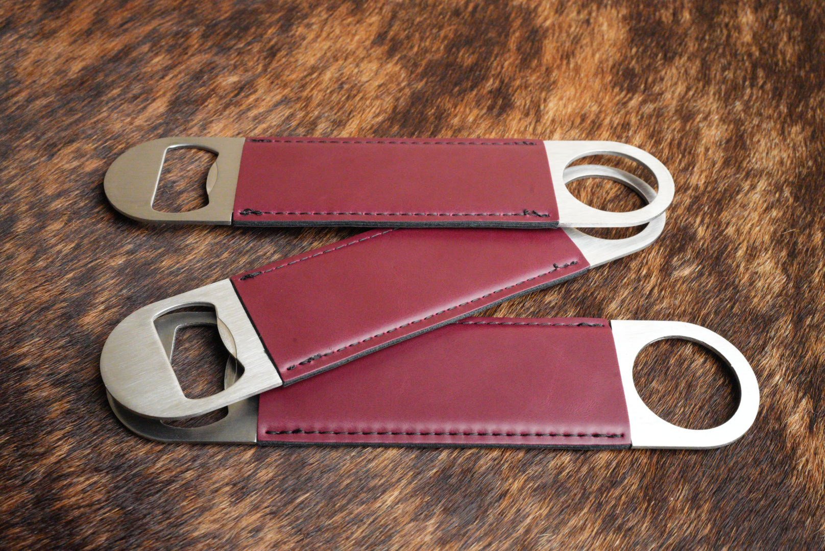 Three stainless steel bar bottle openers wrapped in Maroon Premium Leatherette, fanned out to show the wrap and the opener end.