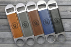 Five Premium Leatherette bottle openers in tan, grey, olive, blue and dark brown fanned across weathered wood, each laser engraved with a sample design.