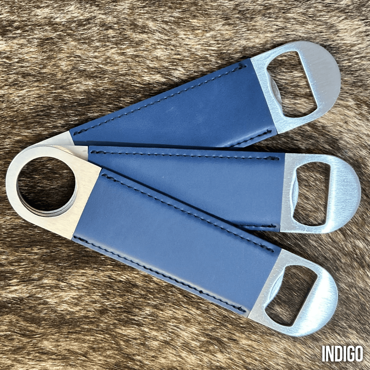 Three stainless steel bar bottle openers wrapped in Indigo blue Premium Leatherette, fanned out to show the wrap and the opener end.