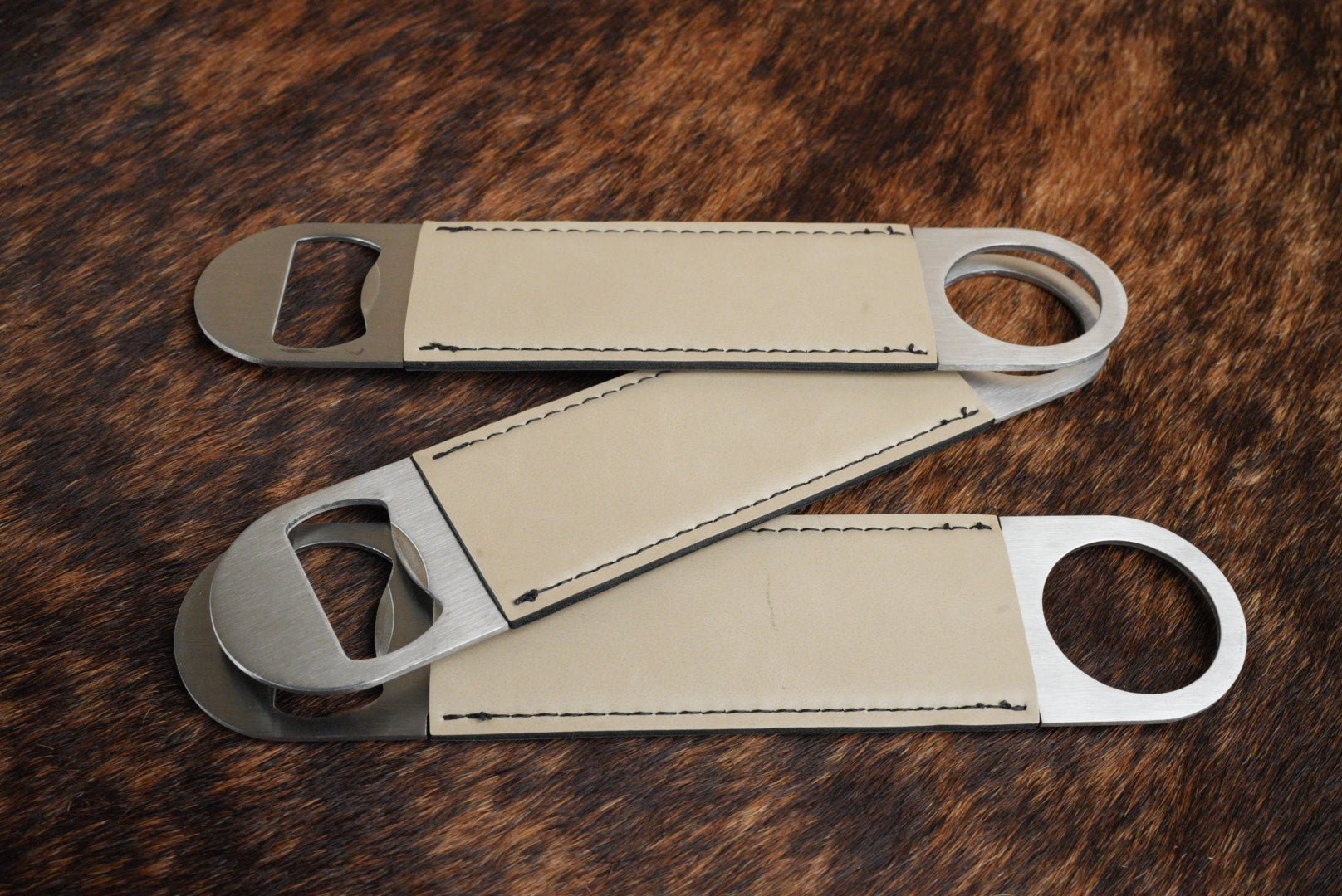 Three stainless steel bar bottle openers wrapped in Sand beige Premium Leatherette, fanned out to show the wrap and the opener end.