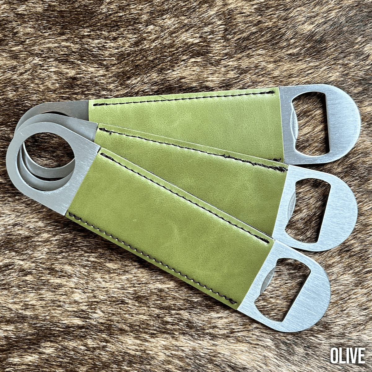 Three stainless steel bar bottle openers wrapped in Olive green Premium Leatherette, fanned out to show the wrap and the opener end.