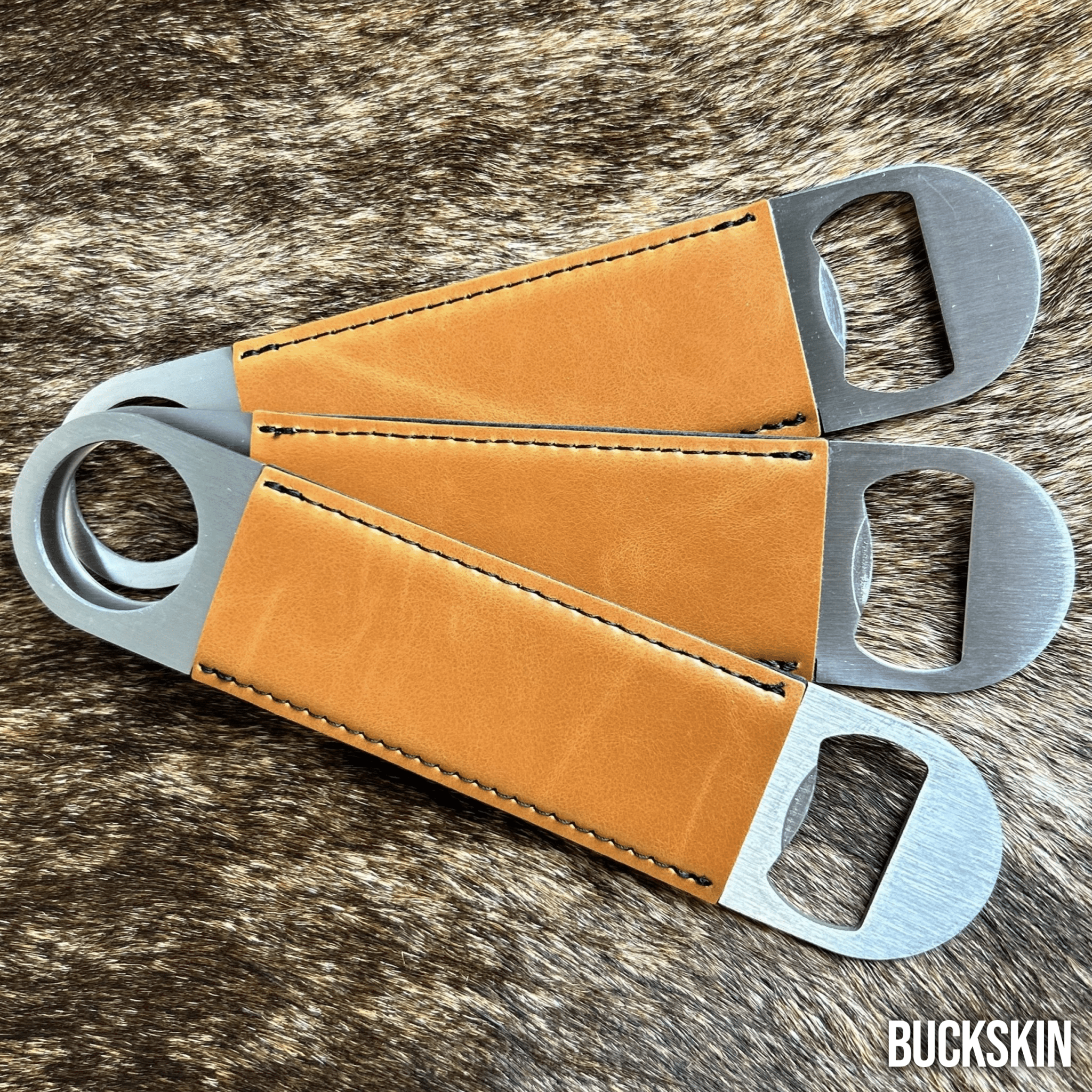 Three stainless steel bar bottle openers wrapped in Buckskin tan Premium Leatherette, fanned out to show the wrap and the opener end.