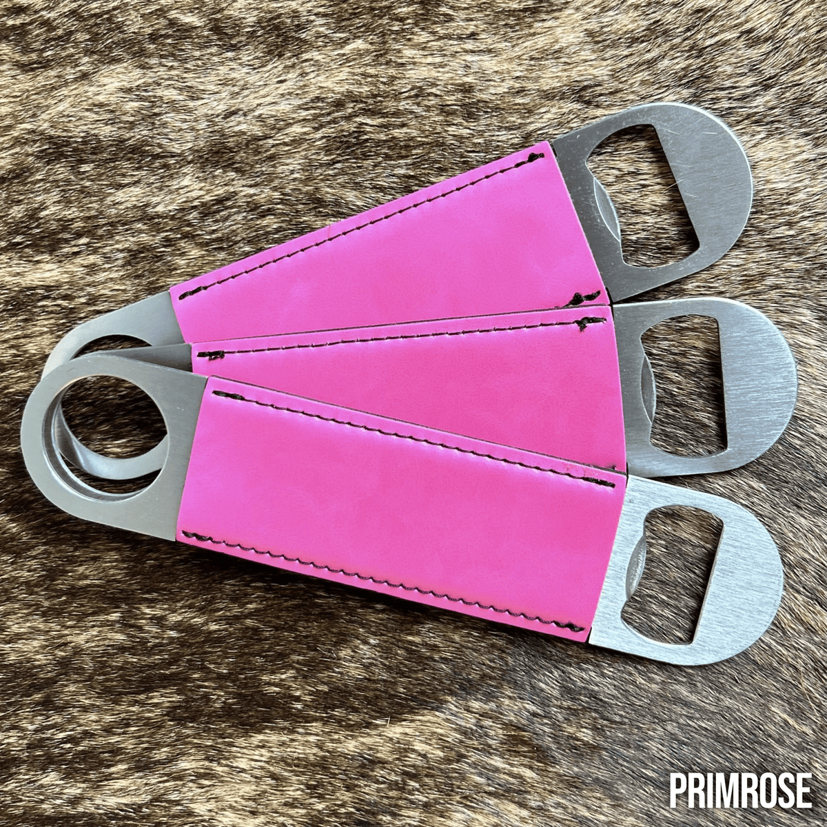 Three stainless steel bar bottle openers wrapped in Primrose pink Premium Leatherette, fanned out to show the wrap and the opener end.