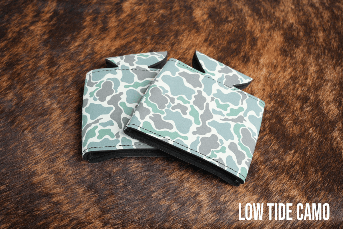 Low Tide Camo Premium Leatherette can coolers in a muted camouflage pattern, laid flat and collapsed.