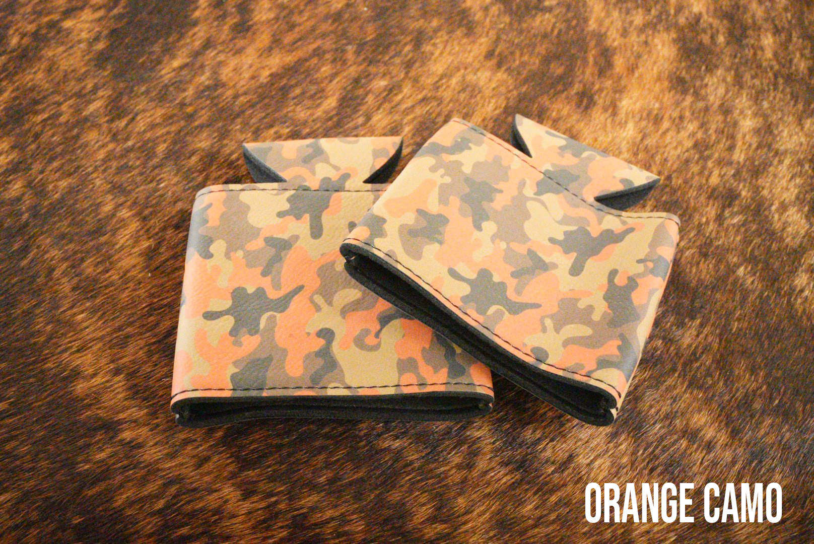 Orange Camo Premium Leatherette can coolers in an orange camouflage pattern, laid flat and collapsed.