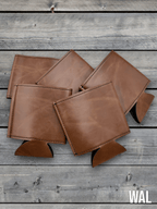 Several Walnut brown Premium Leatherette can coolers laid flat on weathered wood, shown collapsed.