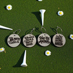 Round wooden golf-themed wine charms arranged on turf with white golf tees