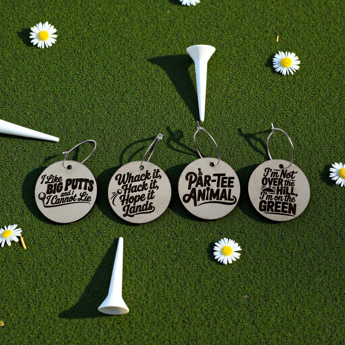 Round wooden golf-themed wine charms arranged on turf with white golf tees