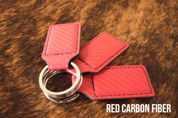 Three red carbon fiber Premium Leatherette keychains with a woven texture, fanned out on a split ring.