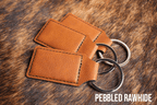 Three Pebbled Rawhide Premium Leatherette keychains with a textured tan grain, fanned out on a split ring.