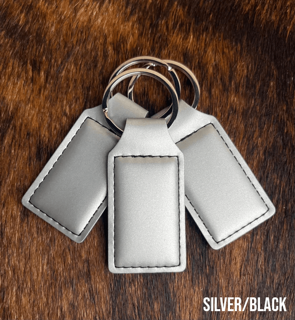 Three silver Premium Leatherette keychains that engrave to black, fanned out on a split ring.