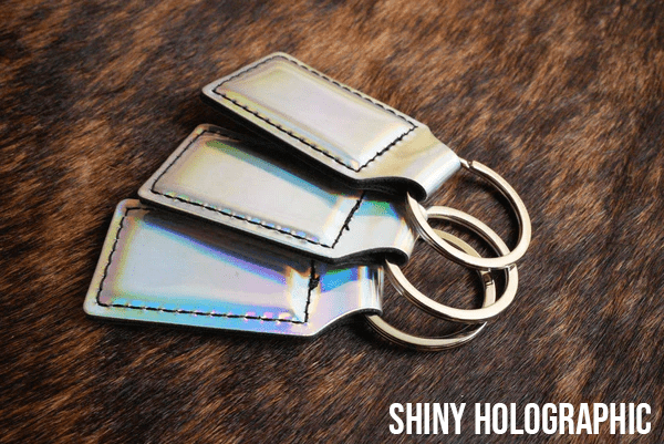 Three shiny holographic Premium Leatherette keychains with a bright iridescent finish, fanned out on a split ring.