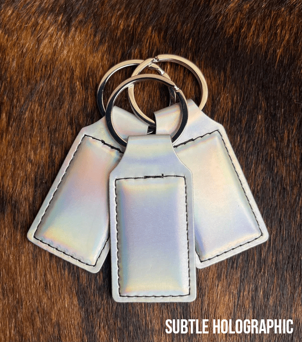 Three subtle holographic Premium Leatherette keychains with a soft iridescent pearl sheen, fanned out on a split ring.