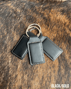 Three black Premium Leatherette keychains that engrave to gold, fanned out on a split ring.