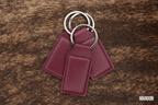 Three Maroon deep red Premium Leatherette keychains fanned out on a split ring, showing the blank engraving panel.