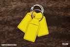 Three Yellow Premium Leatherette keychains fanned out on a split ring, showing the blank engraving panel.