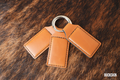 Three Buckskin tan Premium Leatherette keychains fanned out on a split ring, showing the blank engraving panel.