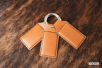 Three Buckskin tan Premium Leatherette keychains fanned out on a split ring, showing the blank engraving panel.
