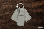 Three Eggshell pale cream Premium Leatherette keychains fanned out on a split ring, showing the blank engraving panel.