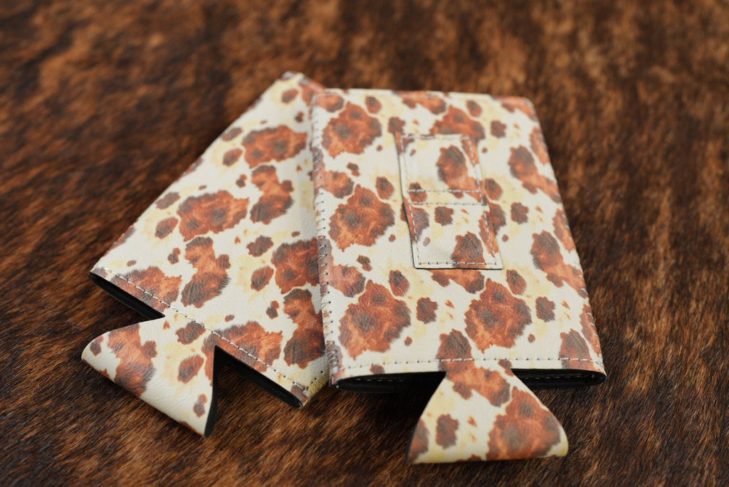 Cowhide print Premium Leatherette magnetic can coozie in brown and white, slim can size, shown folded to reveal the built-in magnets