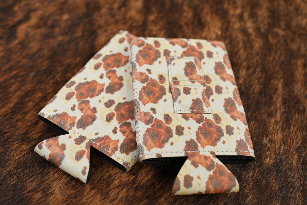 Cowhide print Premium Leatherette magnetic can coozie in brown and white, slim can size, shown folded to reveal the built-in magnets