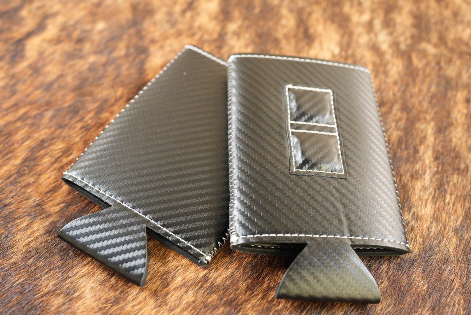 Black carbon fiber Premium Leatherette magnetic can coozie, slim can size, shown folded to reveal the built-in magnets