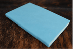 Sky Blue Premium Leatherette journal cover, shown closed on a cowhide surface
