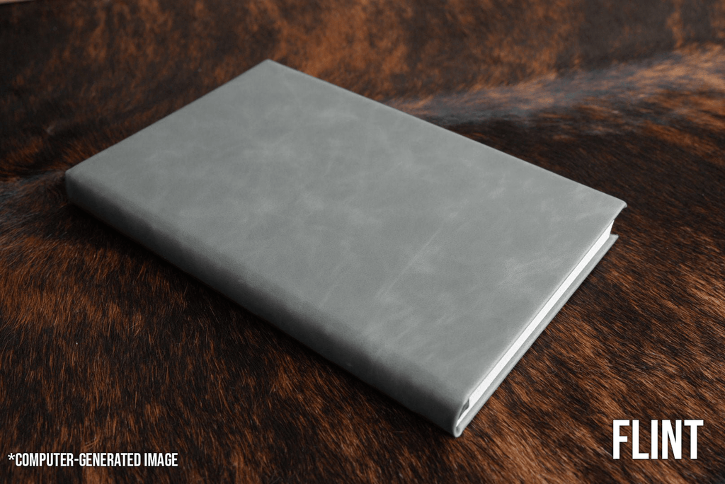 Flint gray Premium Leatherette journal cover, shown closed on a cowhide surface