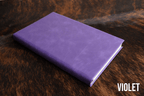 Violet Premium Leatherette journal cover, shown closed on a cowhide surface