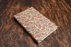 Fowl Play Camo Premium Leatherette journal cover in green, tan and brown, shown closed on a cowhide surface