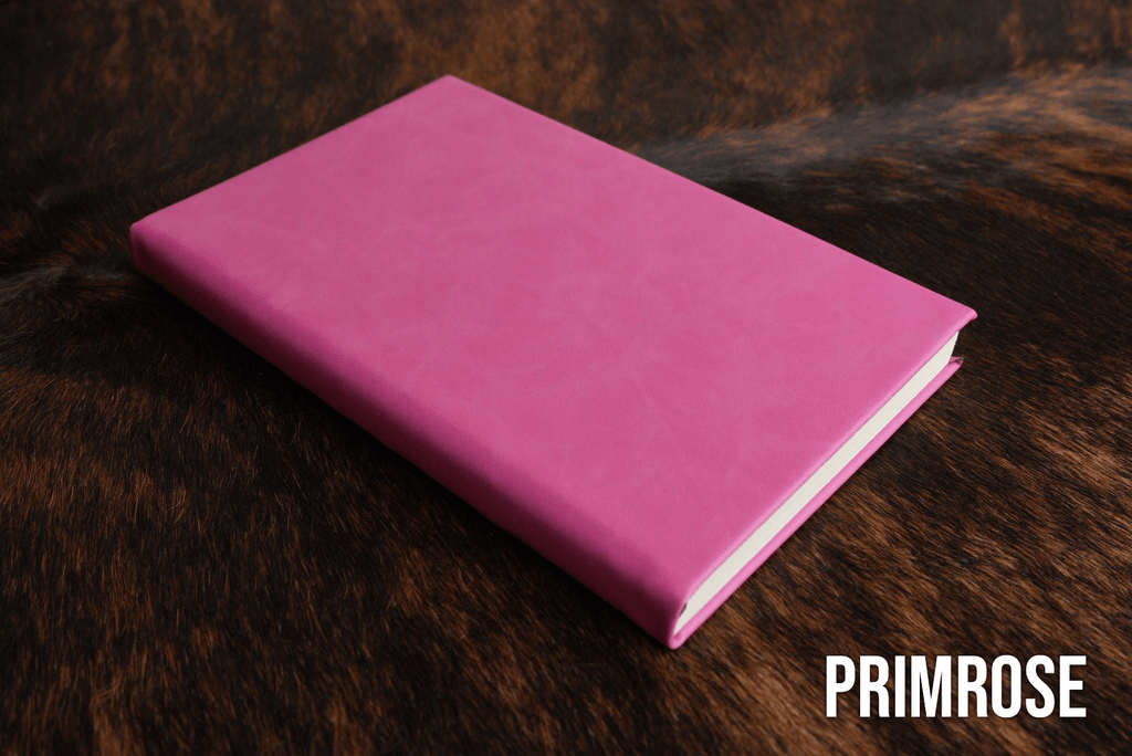 Primrose pink Premium Leatherette journal cover, shown closed on a cowhide surface