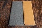 Saddle Tan Premium Leatherette padfolio, shown closed on a cowhide surface