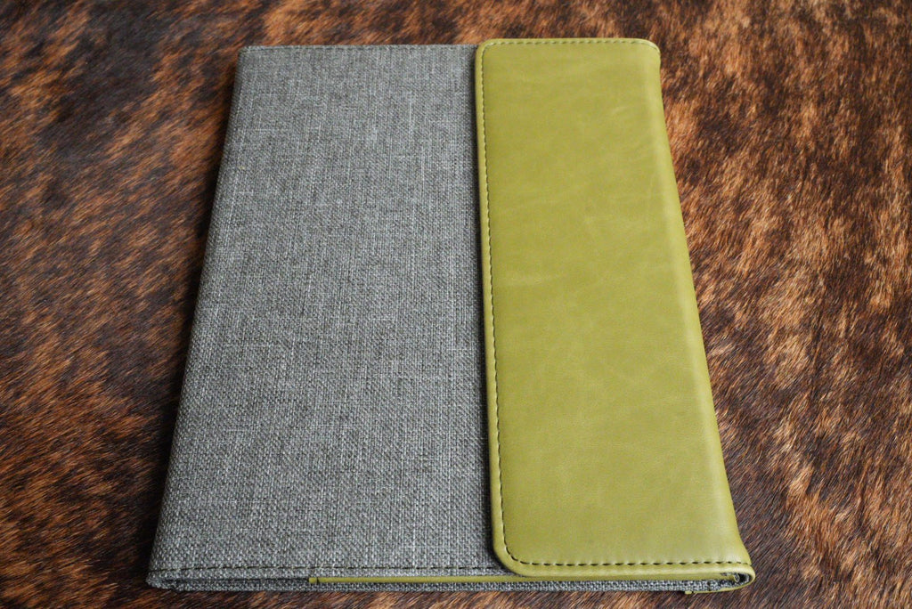 Olive green Premium Leatherette padfolio, shown closed on a cowhide surface